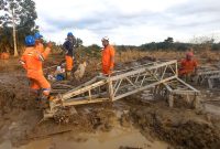 Di tengah medan yang berlumpur, petugas PLN melakukan perakitan tower darurat di jalur transmisi Langsa-Pangkalan Brandan.