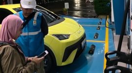 Pengguna EV asal Depok, Jawa Barat, Ufi Desi Fatmawati (kiri) ketika mengisi daya kendaraannya di Rest Area Tol 228A Kanci–Pejagan pada Rabu (24/12). Menurutnya, ketersediaan fasilitas pengisian daya di sepanjang jalur mudik memberikan rasa tenang selama perjalanan menuju kampung halamannya di Purwokerto, Jawa Tengah.