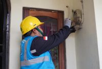 Ilustrasi Petugas PLN saat melakukan penggantian miniature circuit breaker (MCB) pada kWh meter di salah satu rumah pelanggan untuk proses tambah daya listrik.